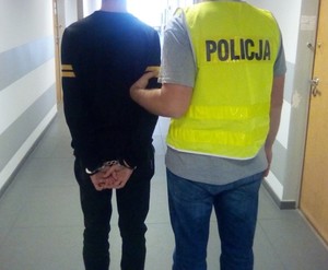 policjant i zatrzymany mężczyzna z kajdankami na rękach