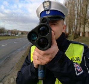 policjant z urządzeniem do pomiaru prędkości pojazdów